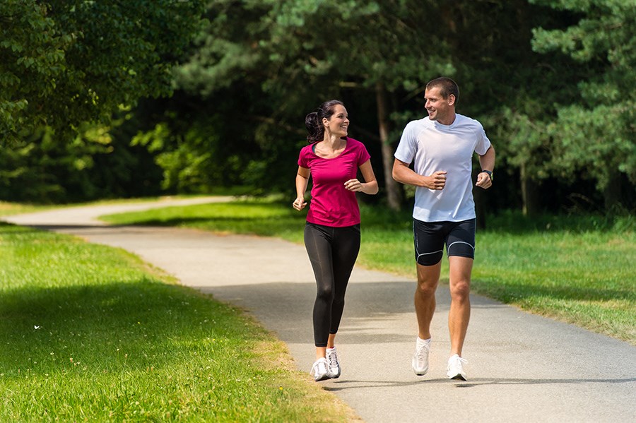 a man and a woman running down a sidewalk