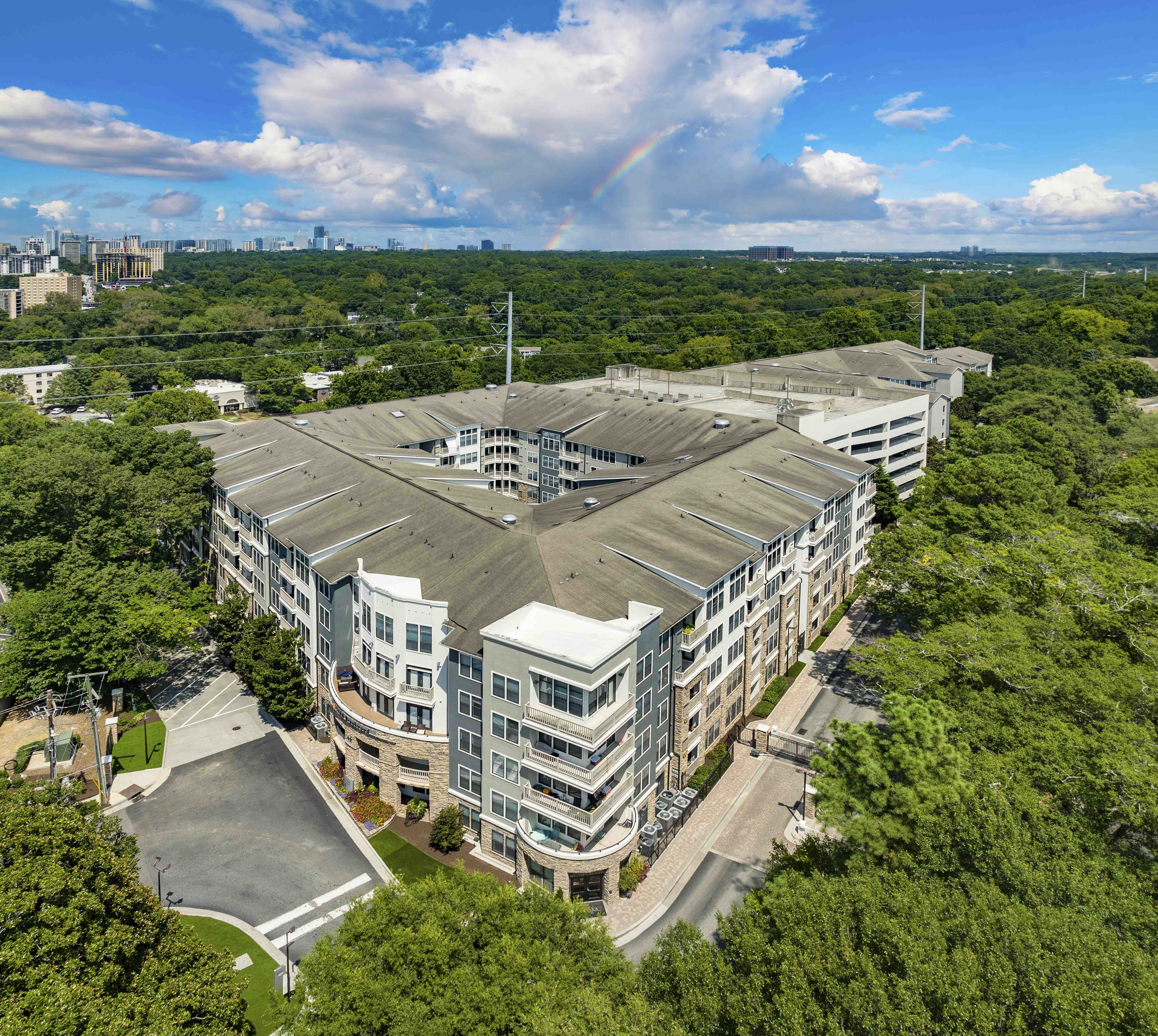 an aerial view of an apartment building with a rainbow in the background