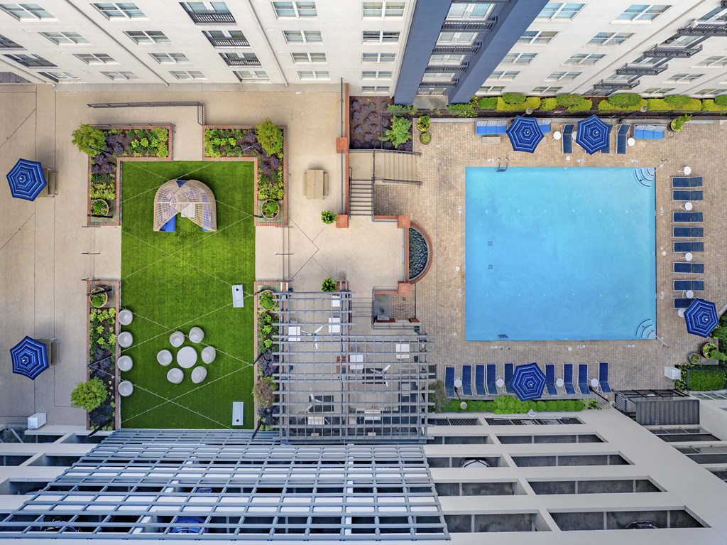 an aerial view of a swimming pool and a courtyard with grass