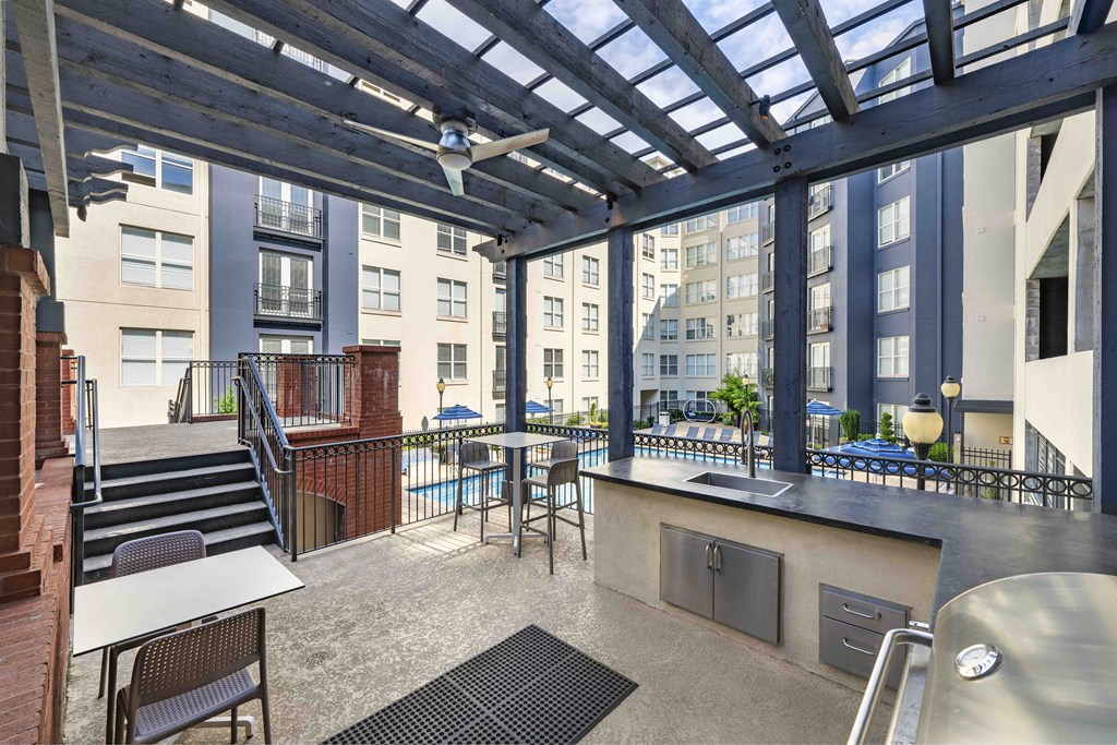 a communal area with tables and chairs and a kitchen and a pool