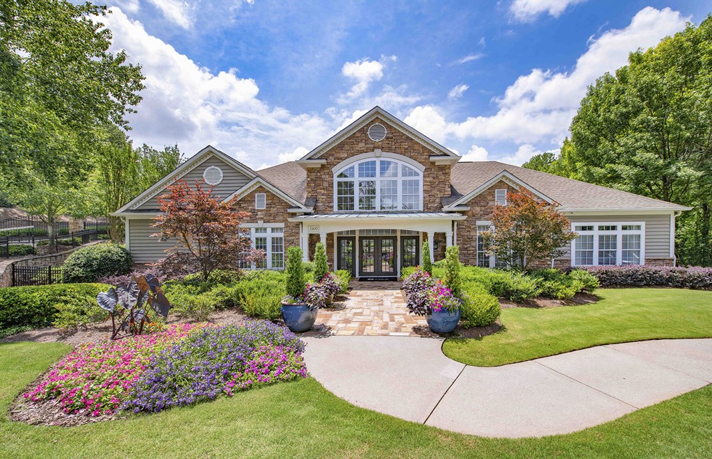 the front of a house with flowers and a driveway