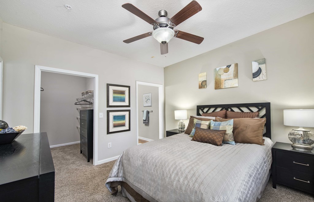 a bedroom with a ceiling fan and a bed