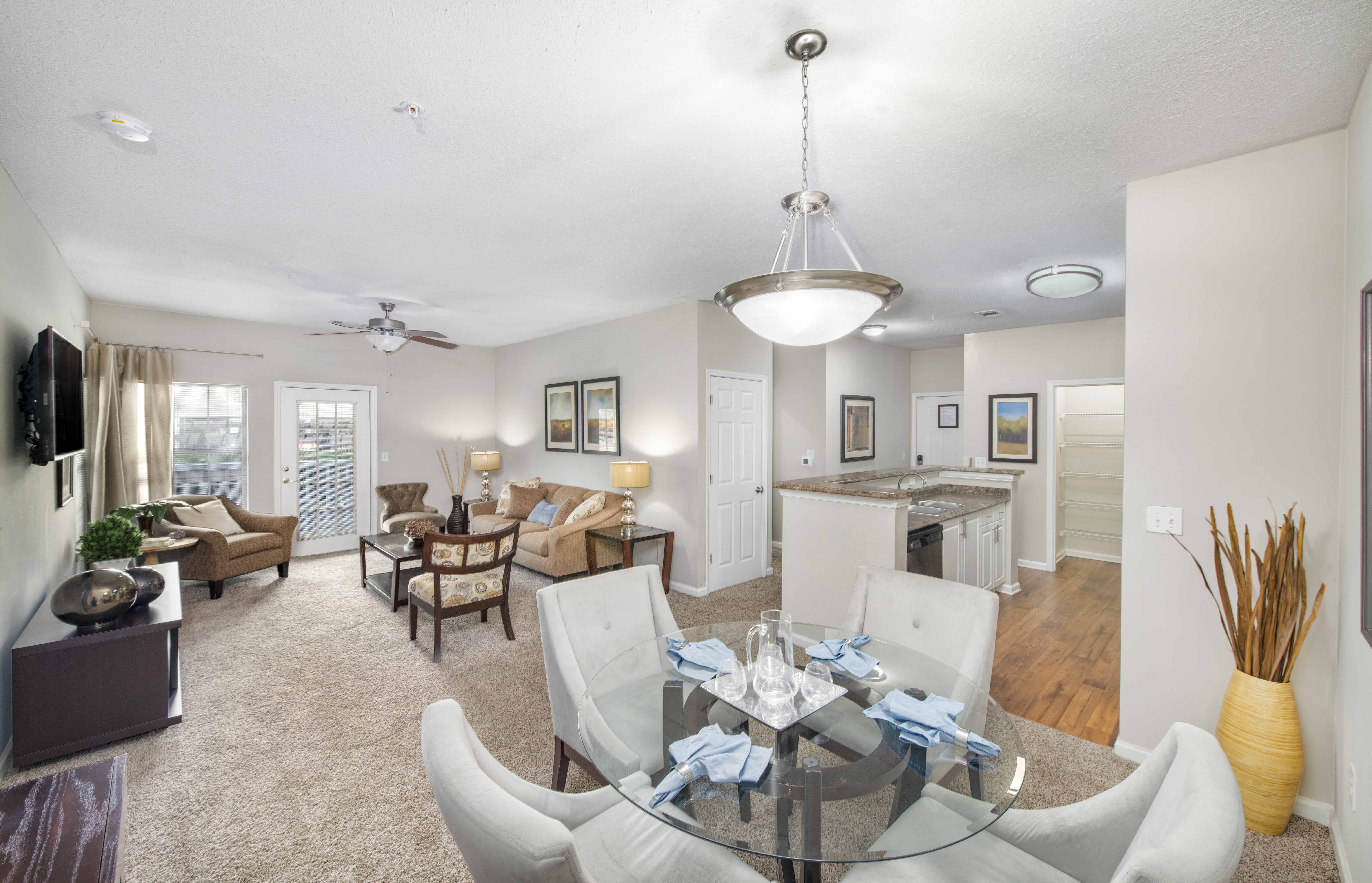 a living room and dining room with a glass table
