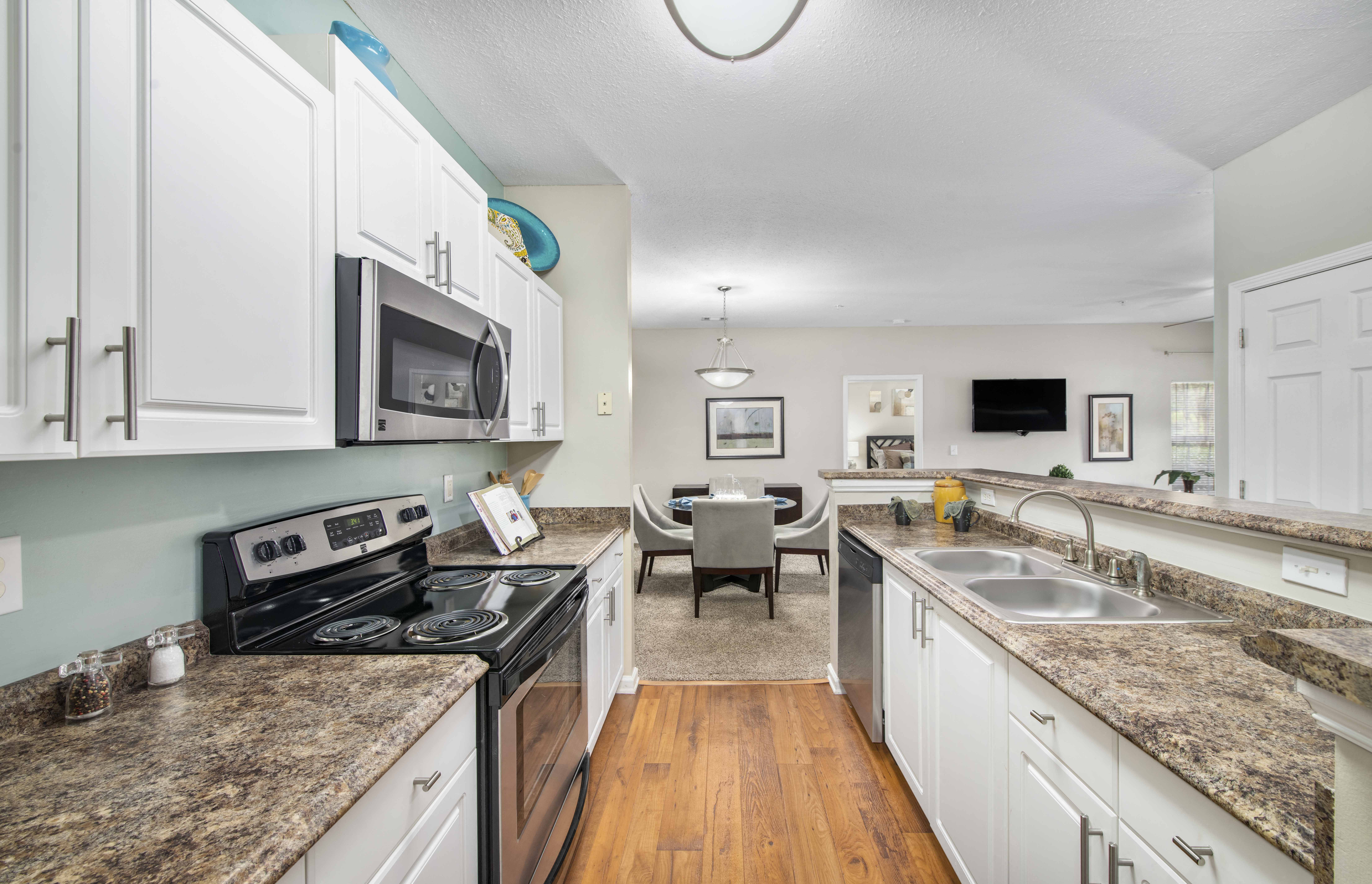 a kitchen with marble counter tops and white cabinets