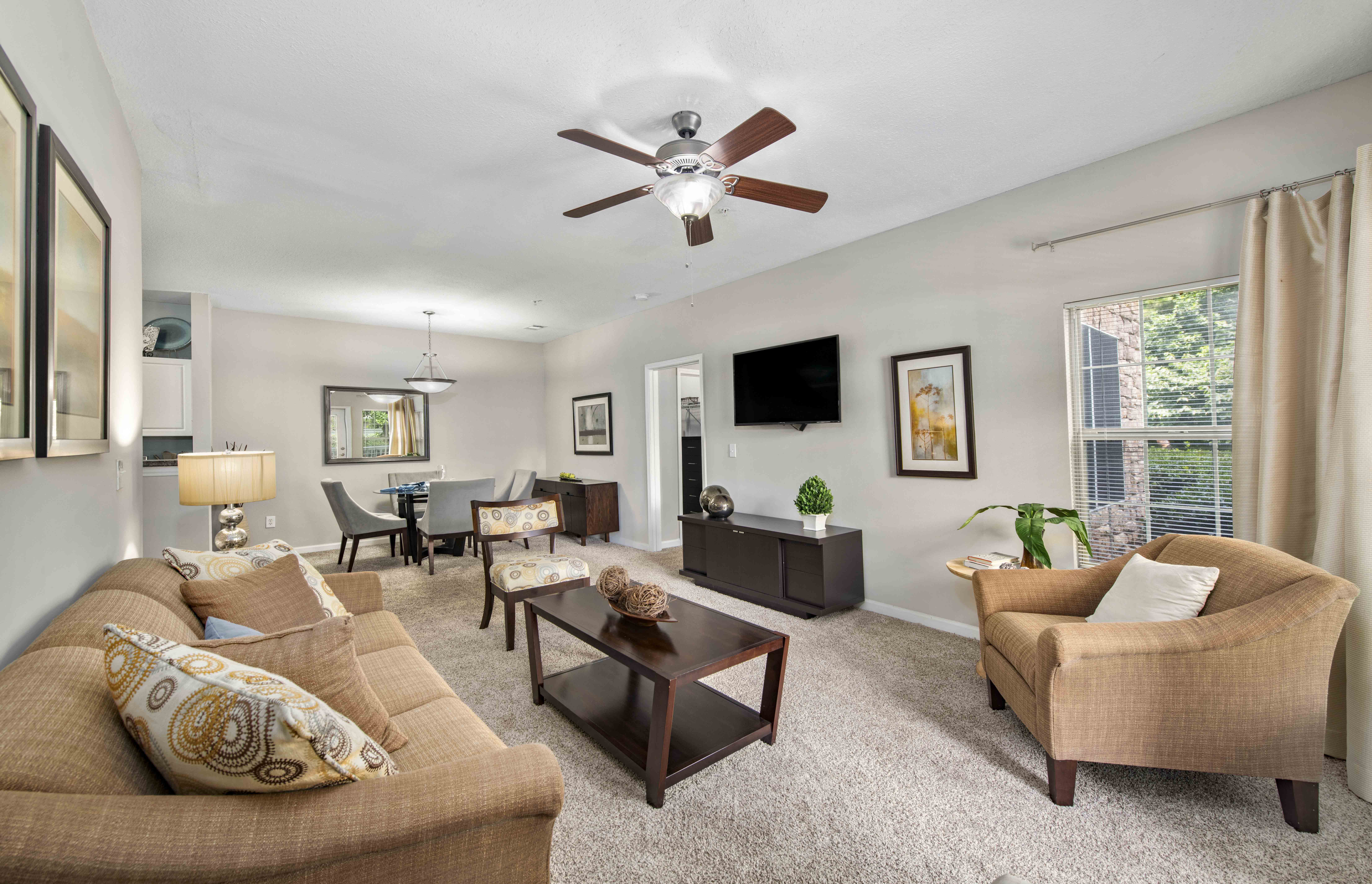 a living room with a couch and a ceiling fan