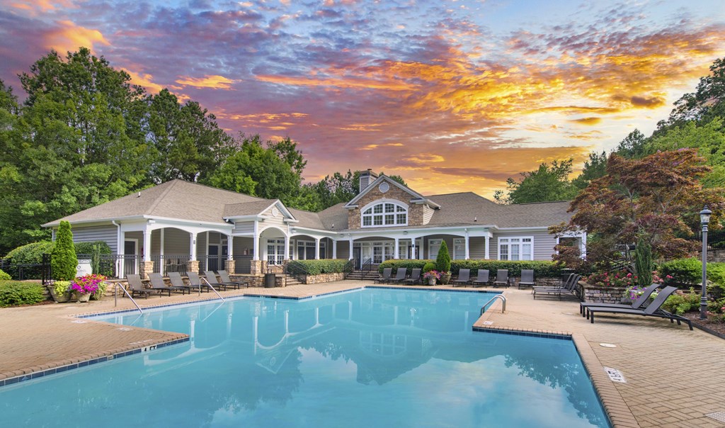 a pool with a house in the background and a cloudy sky