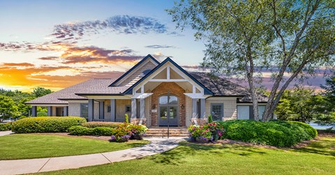 A house with a front yard and a sunset in the background.
