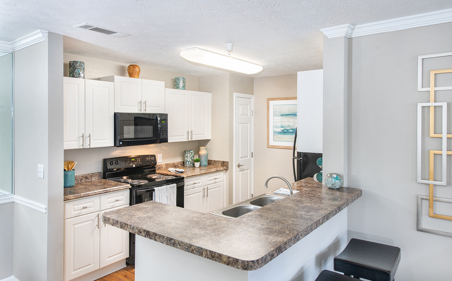 a kitchen with white cabinets and a granite counter top