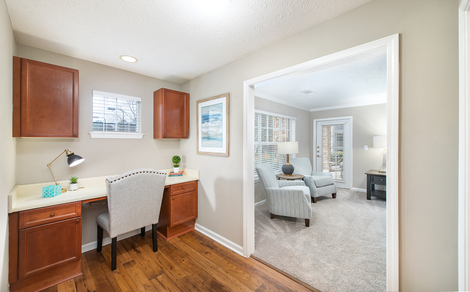 a home office with a desk and a living room with a couch