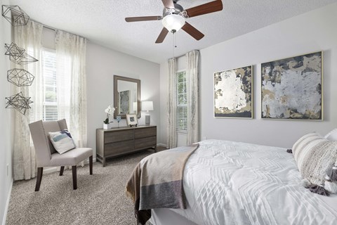 an expansive bedroom with a large bed and a ceiling fan