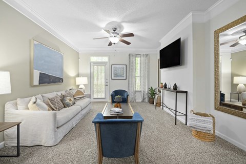 a living room with a white couch and a ceiling fan