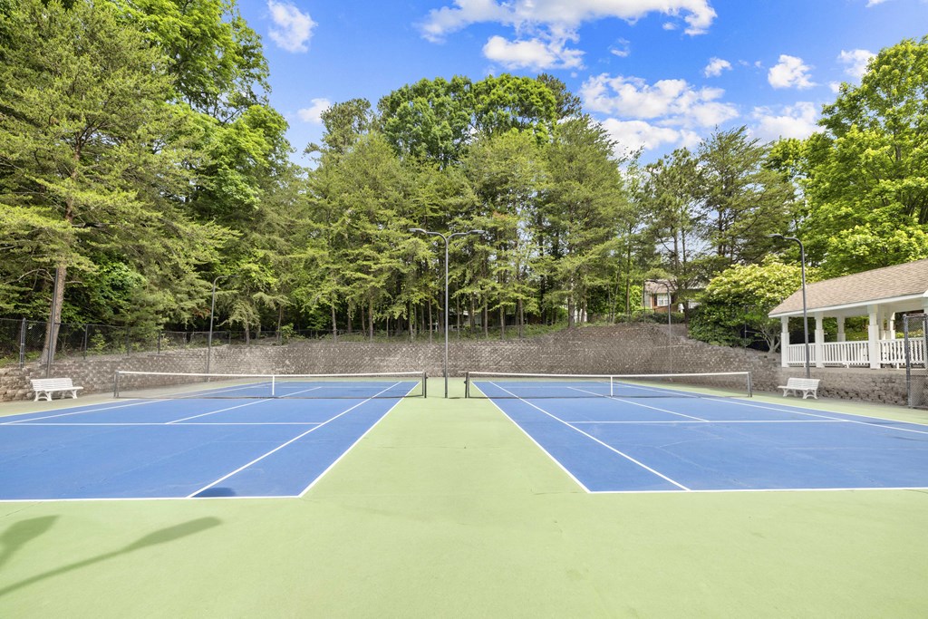 a tennis court with a house on the side of it
