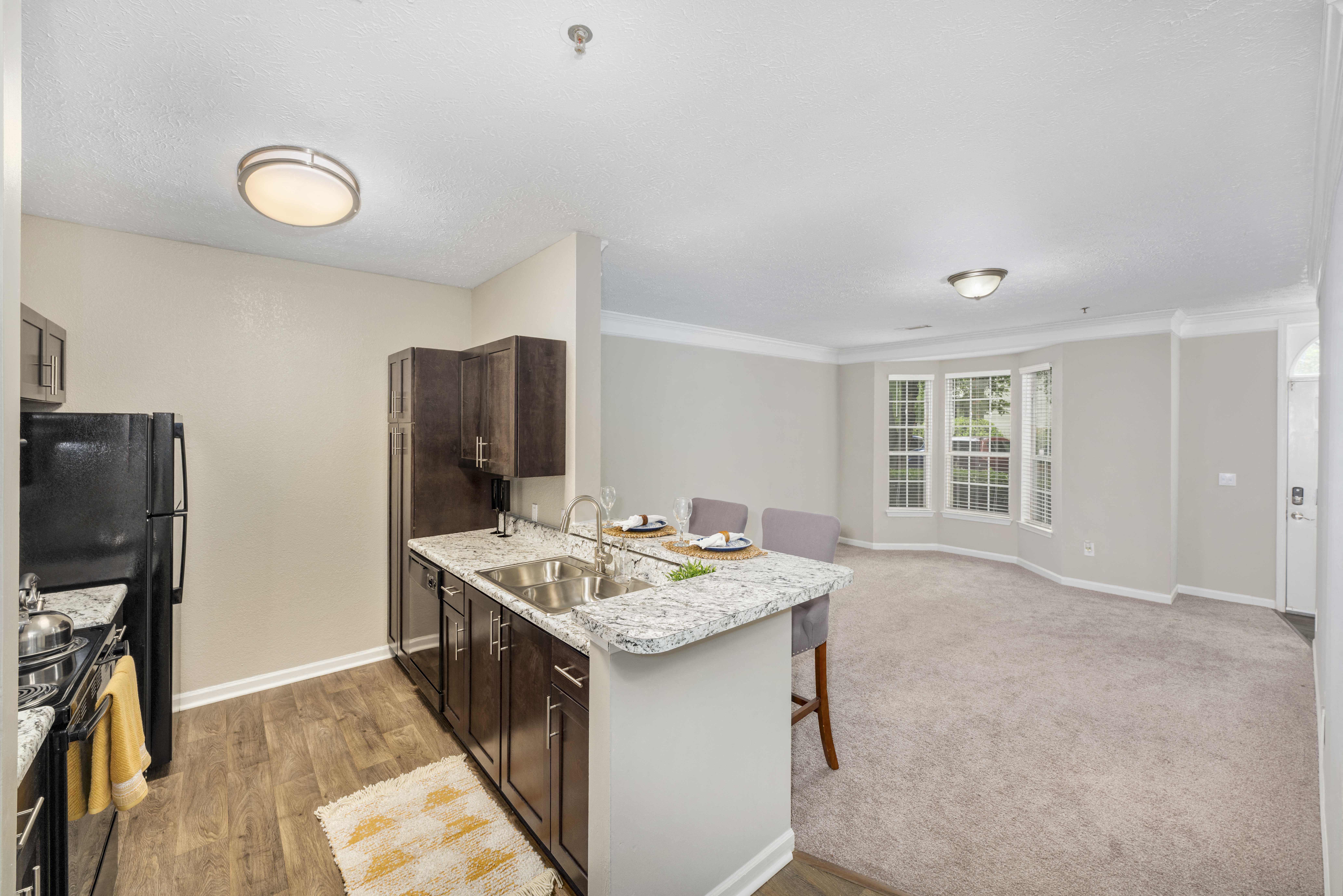 a kitchen with a sink and a counter top in a living room