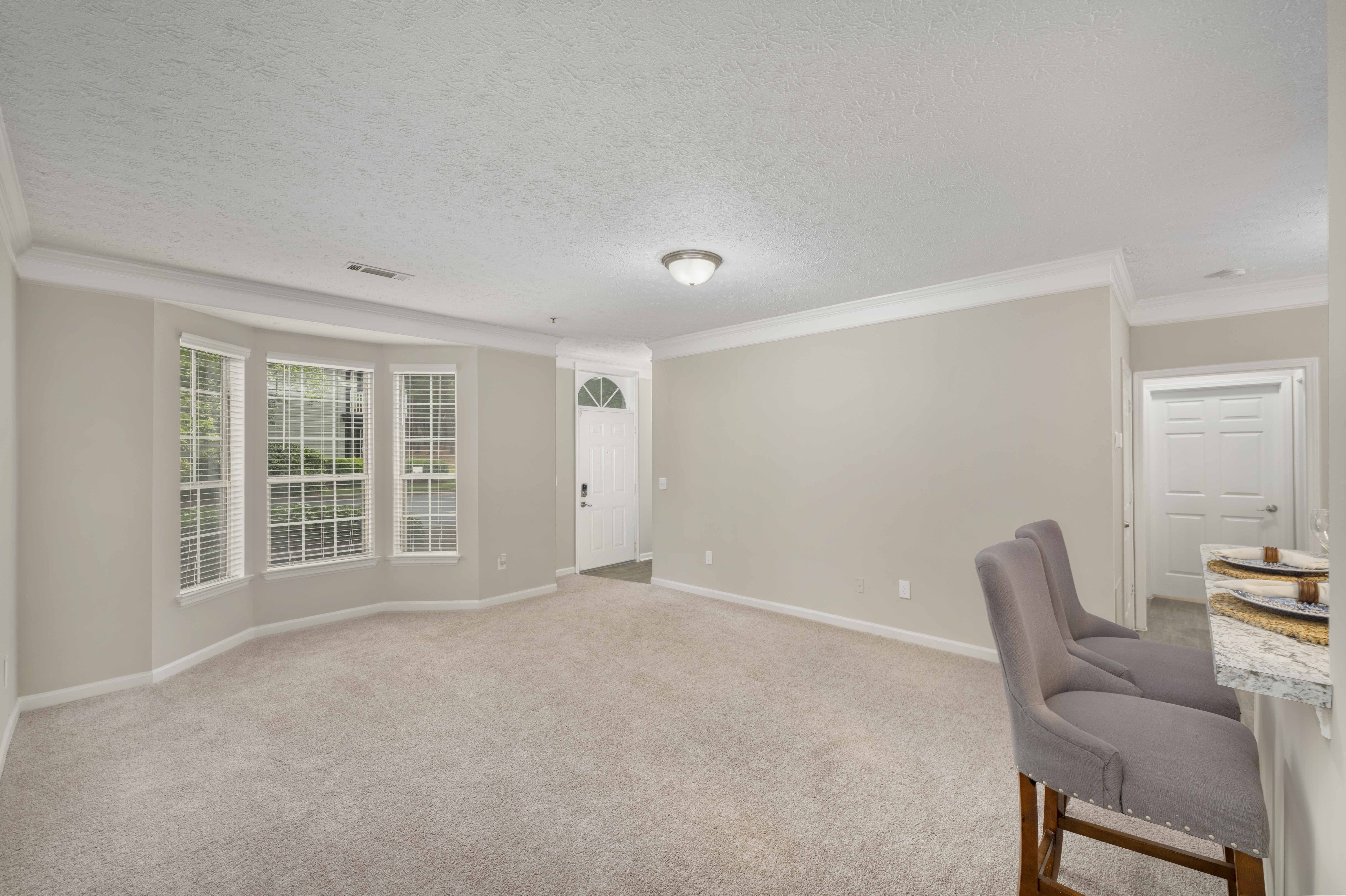 an empty living room with a chair and a table