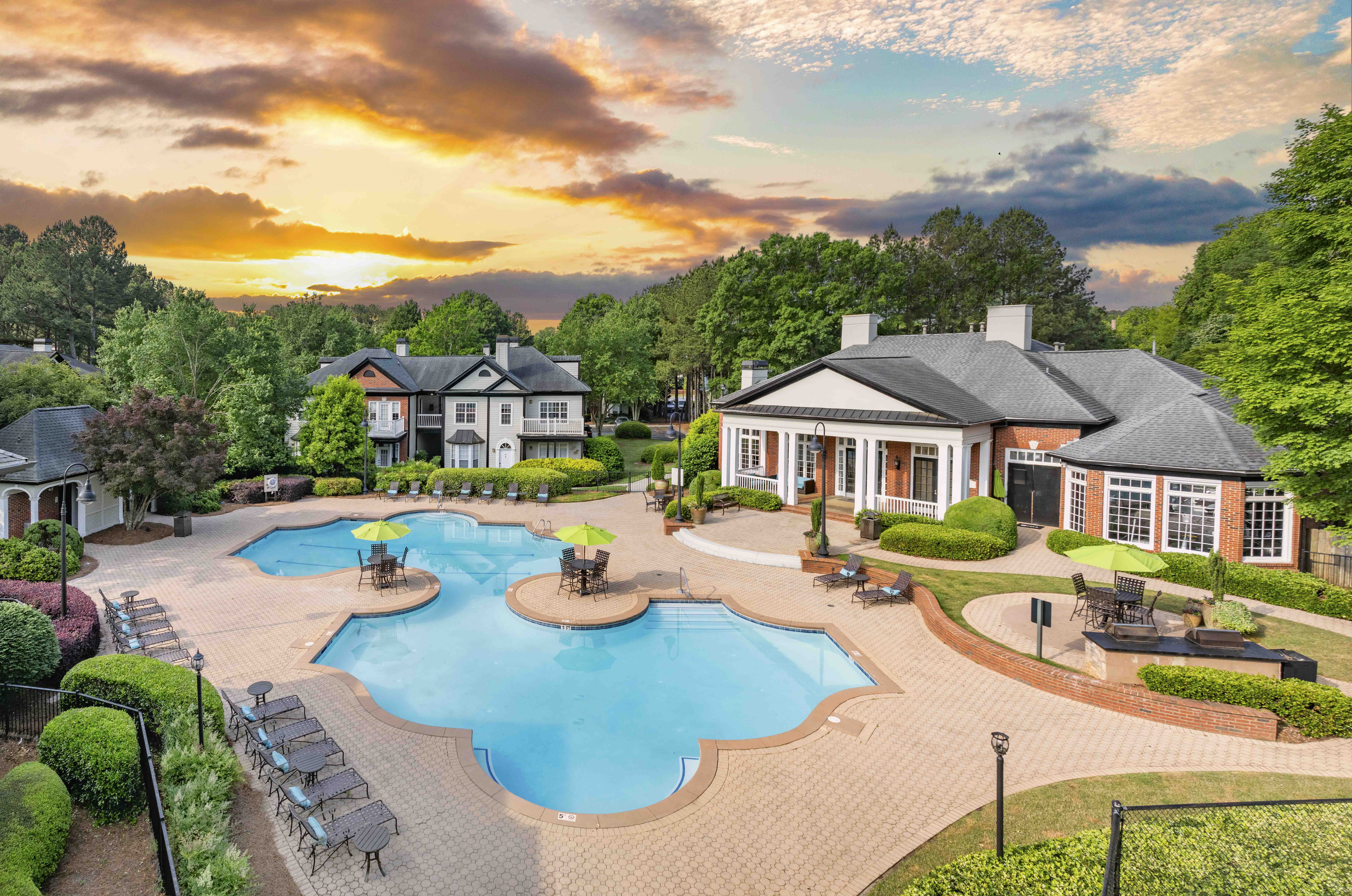 an aerial view of a swimming pool with a house in the background