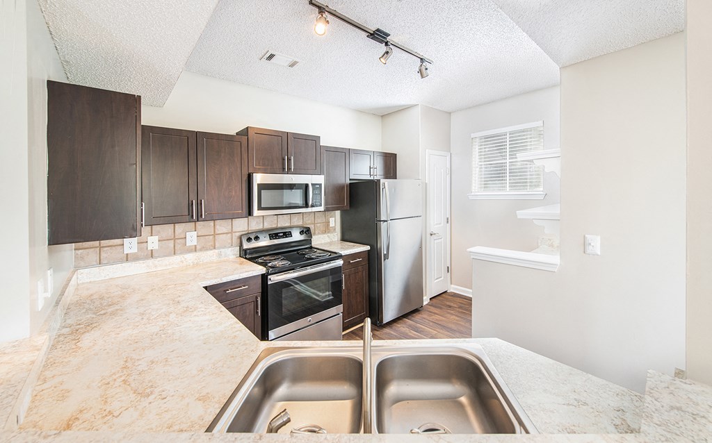 a renovated kitchen with stainless steel appliances and white counter tops