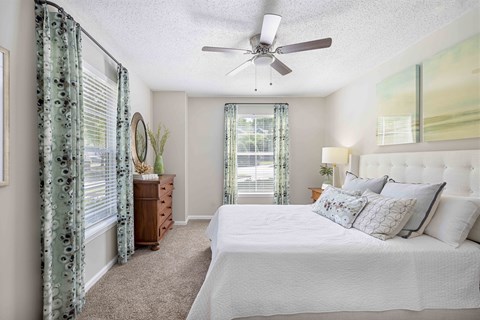 a bedroom with a large bed and a ceiling fan