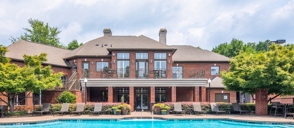 a large brick house with a swimming pool in front of it