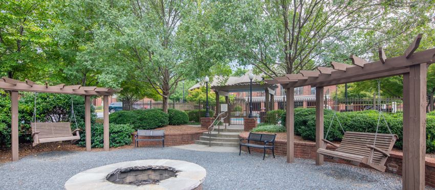 a patio with benches and a fire pit