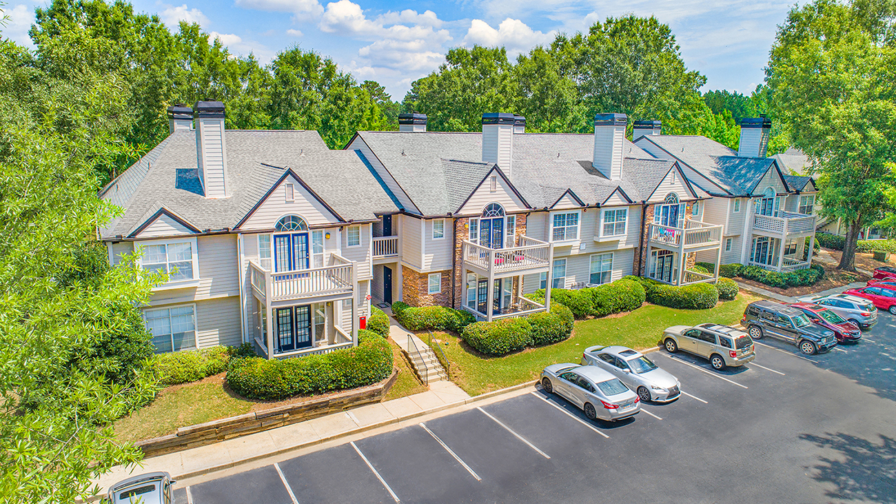 a row of houses with cars parked in a parking lot