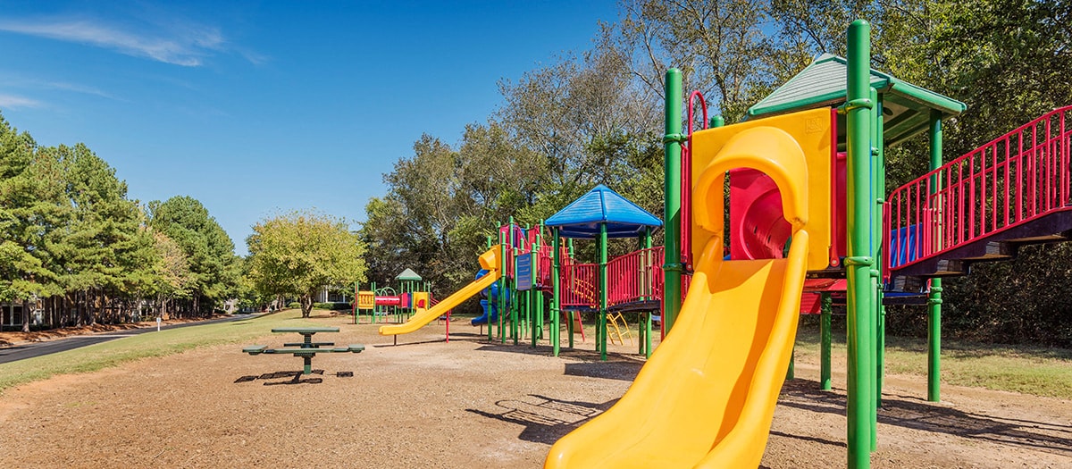 a playground at a park with slides and a picnic table