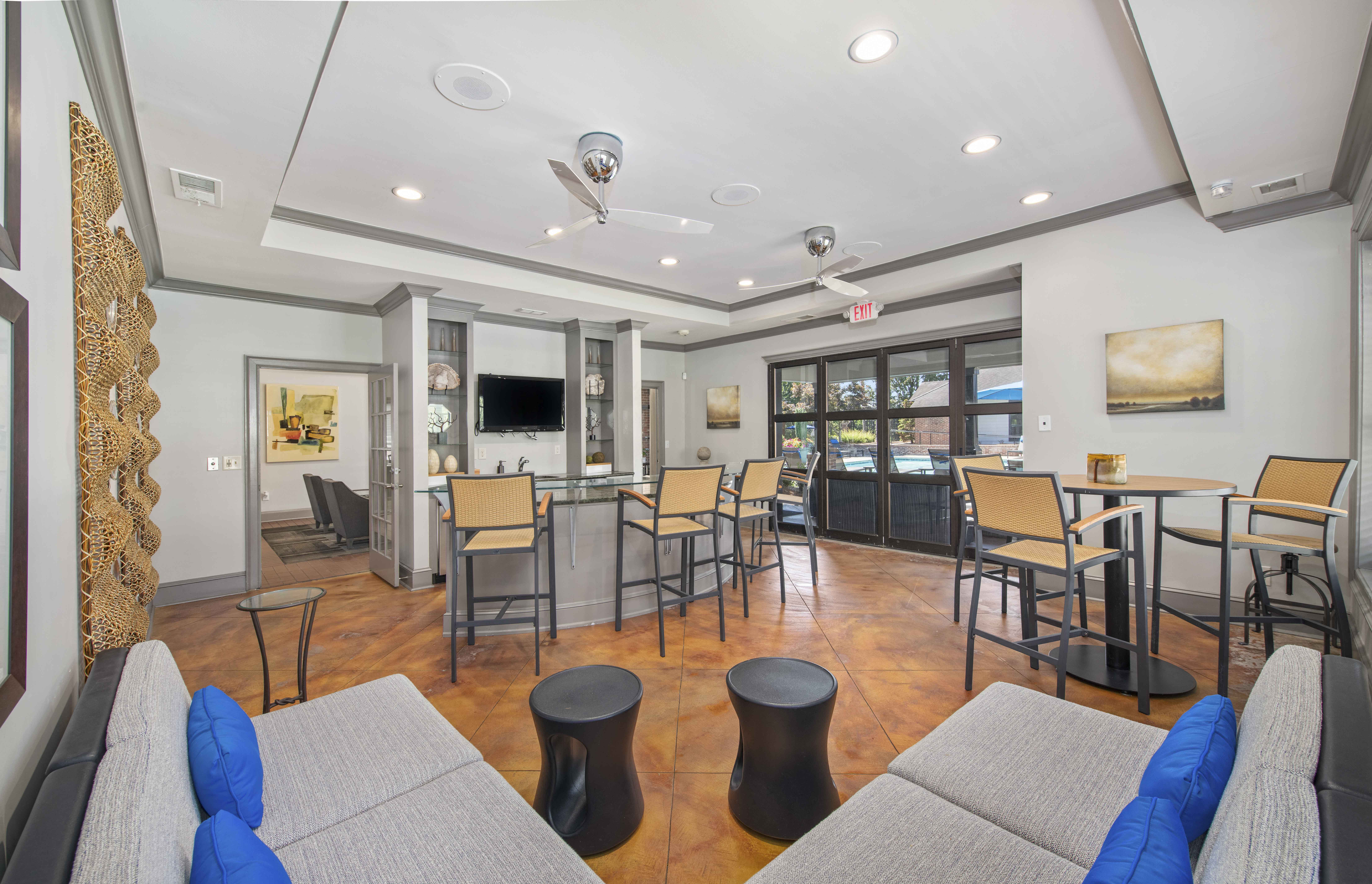a living room with couches and chairs and a bar with tables and chairs