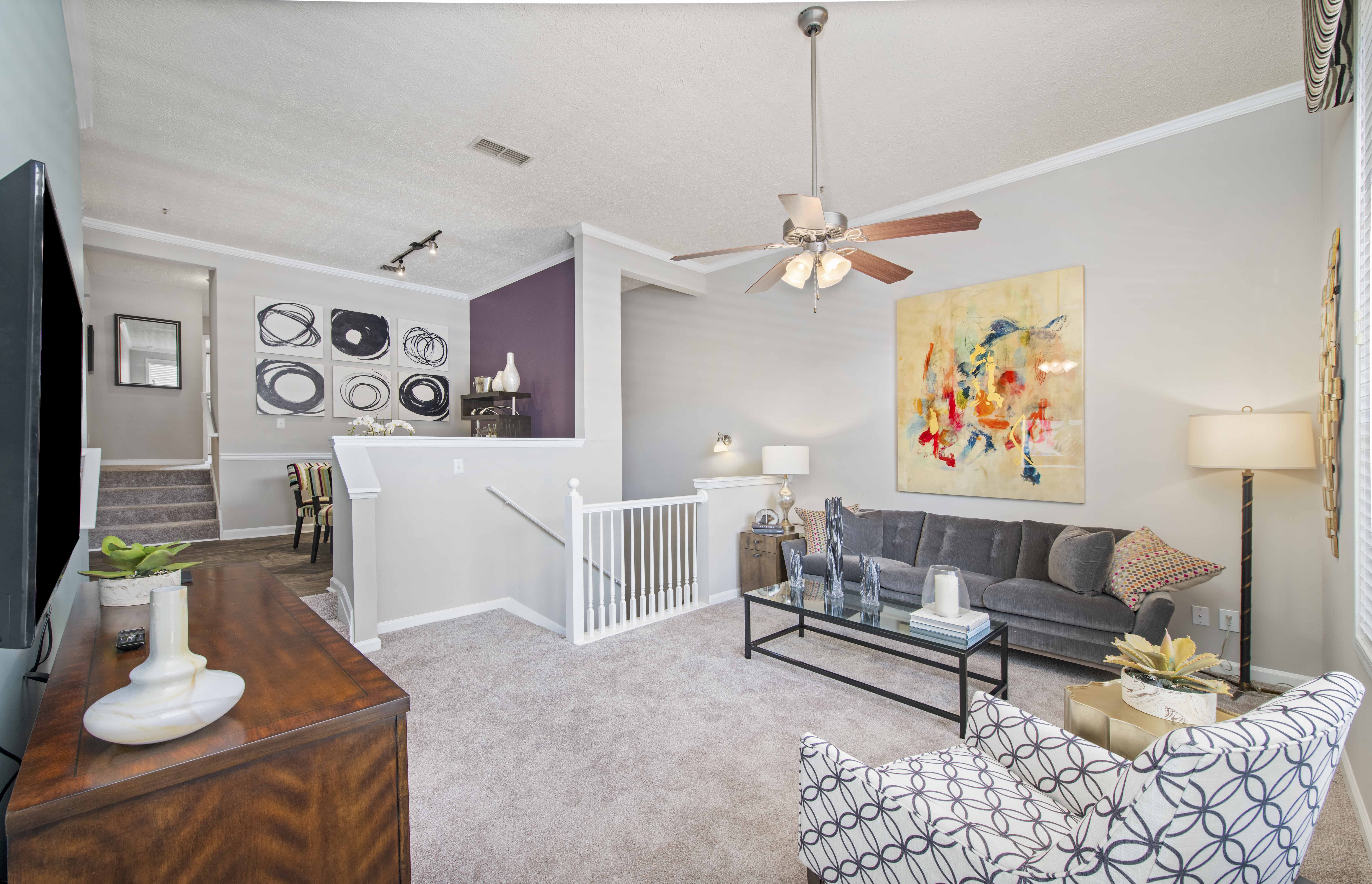 a living room with a couch and a ceiling fan