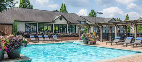 a swimming pool with lounge chairs and a house with a pool