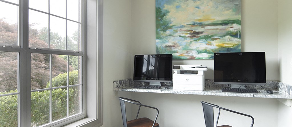 a desk with a computer and a window
