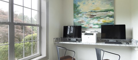 a desk with a computer and a window