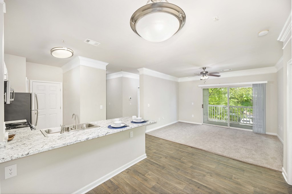 a kitchen and living room with a sliding glass door to a patio