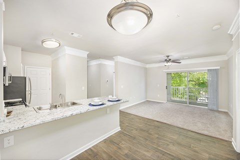 a kitchen and living room with a sliding glass door to a patio