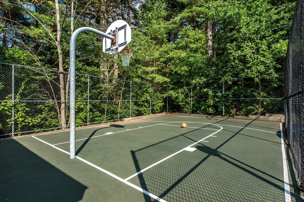 a basketball court with a hoop and a yellow ball on it