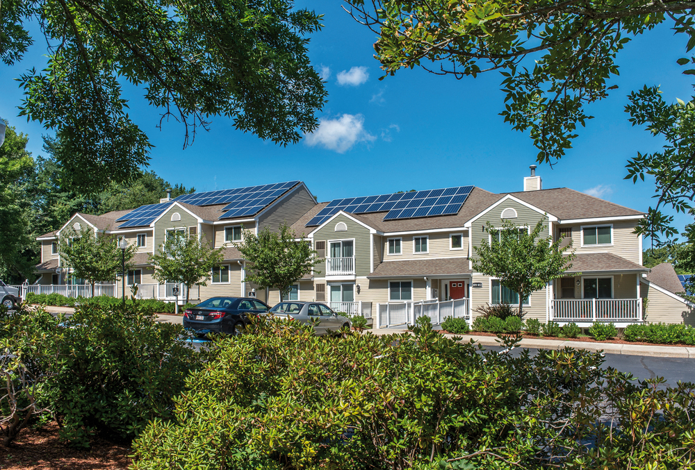 a row of houses with solar panels on their roofs