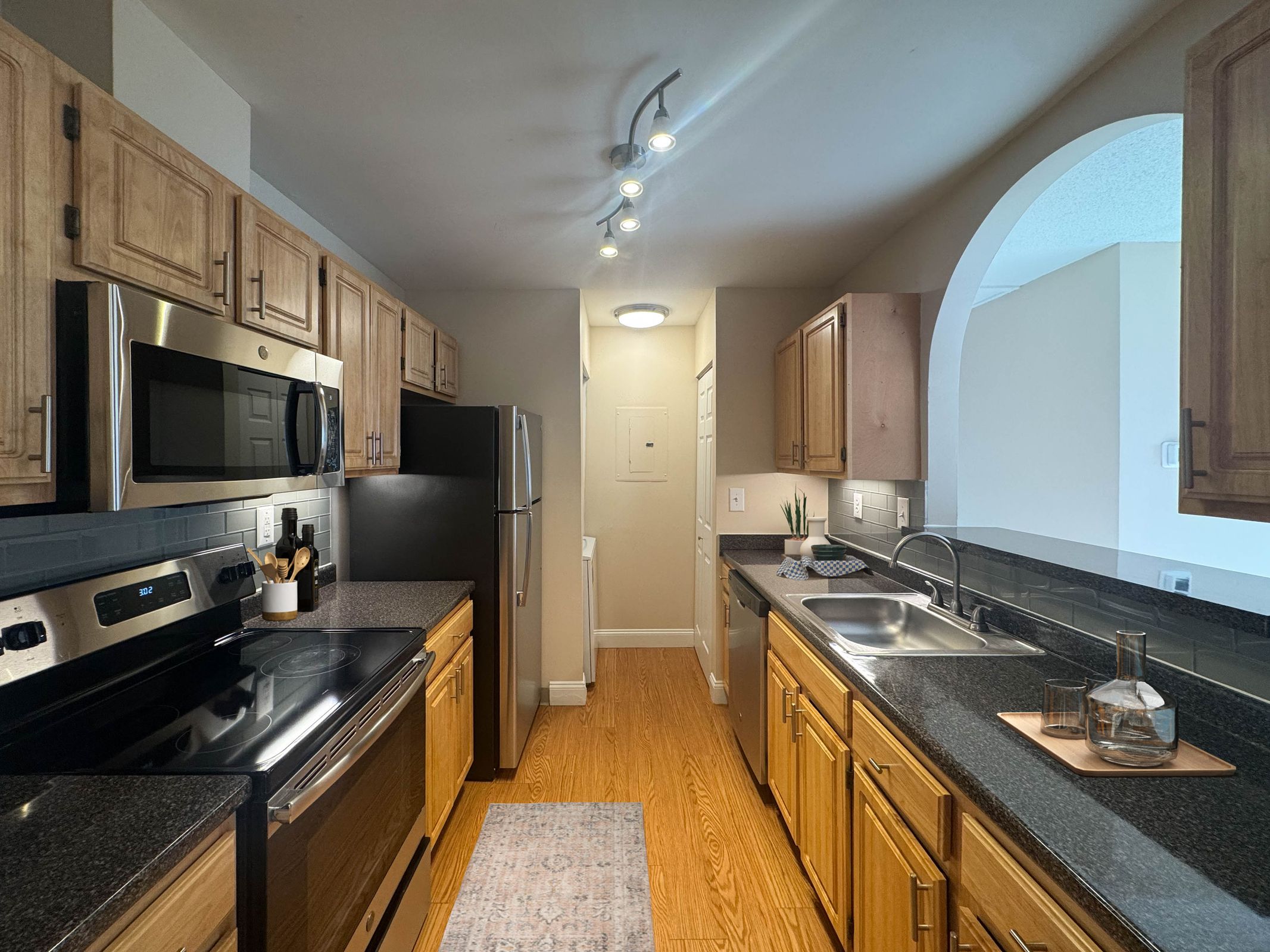 A kitchen with wooden cabinets and black countertops.