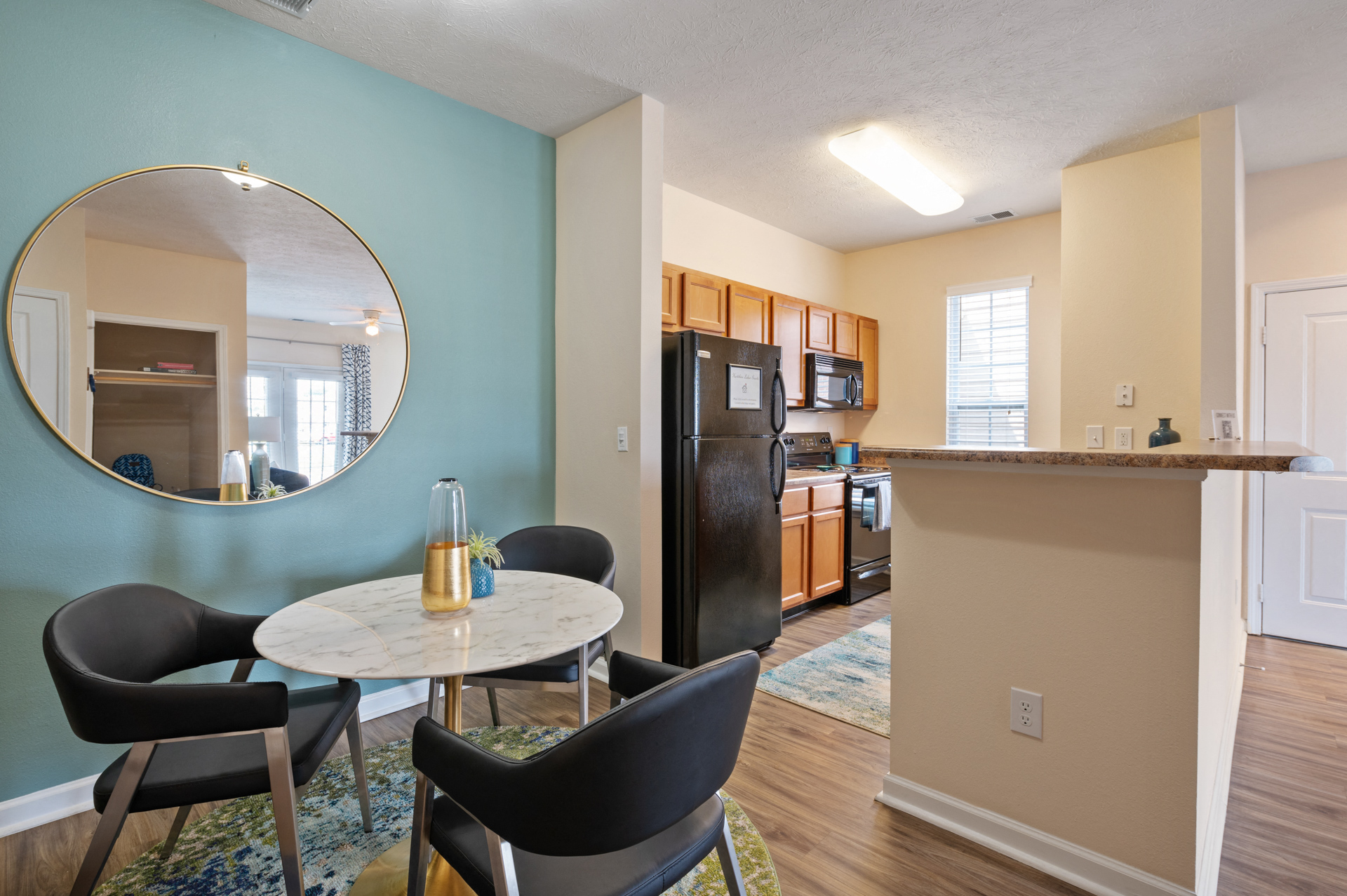 A kitchen with a table and chairs in front of a blue wall.