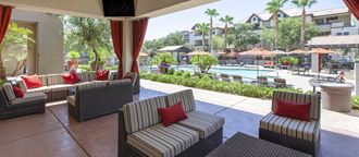 a patio with chairs and a pool at a resort