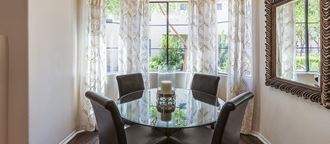 a dining room with a table and chairs in front of a window