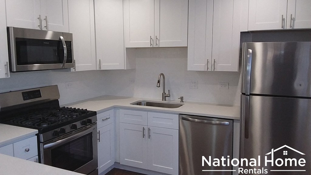 a kitchen with white cabinets and stainless steel appliances