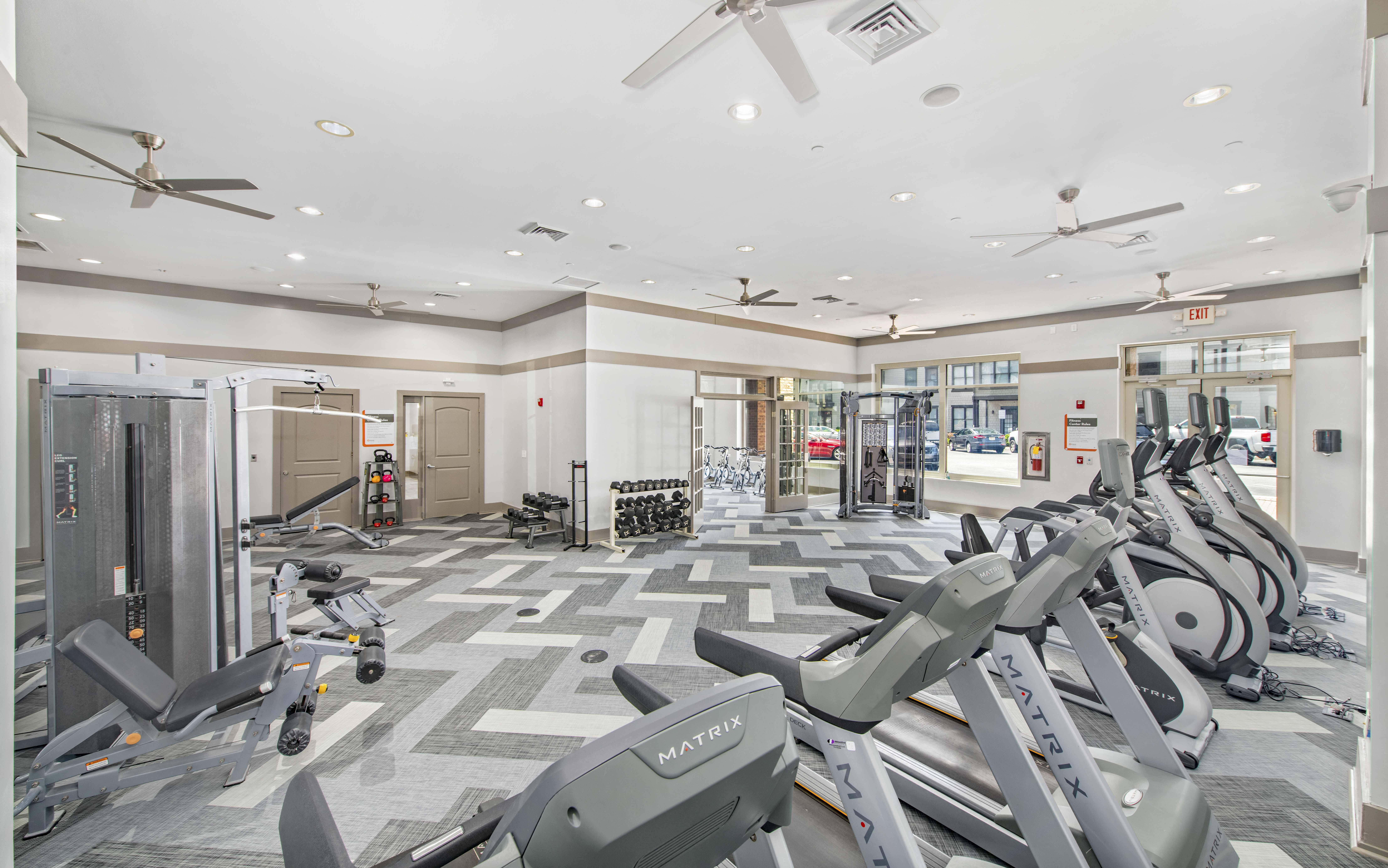 a gym with cardio machines and weights on the floor
