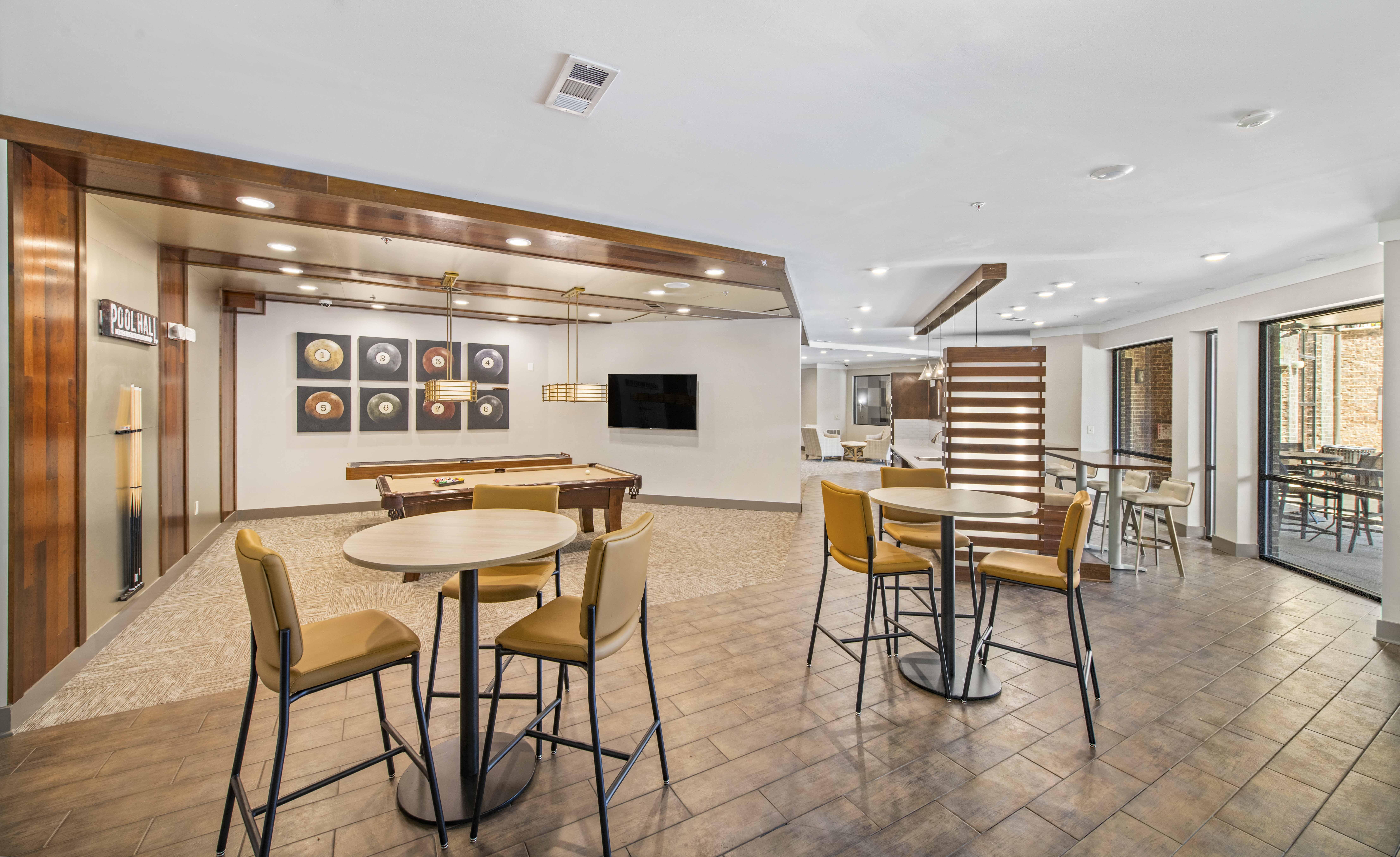 a clubhouse with tables and chairs and a bar and a television