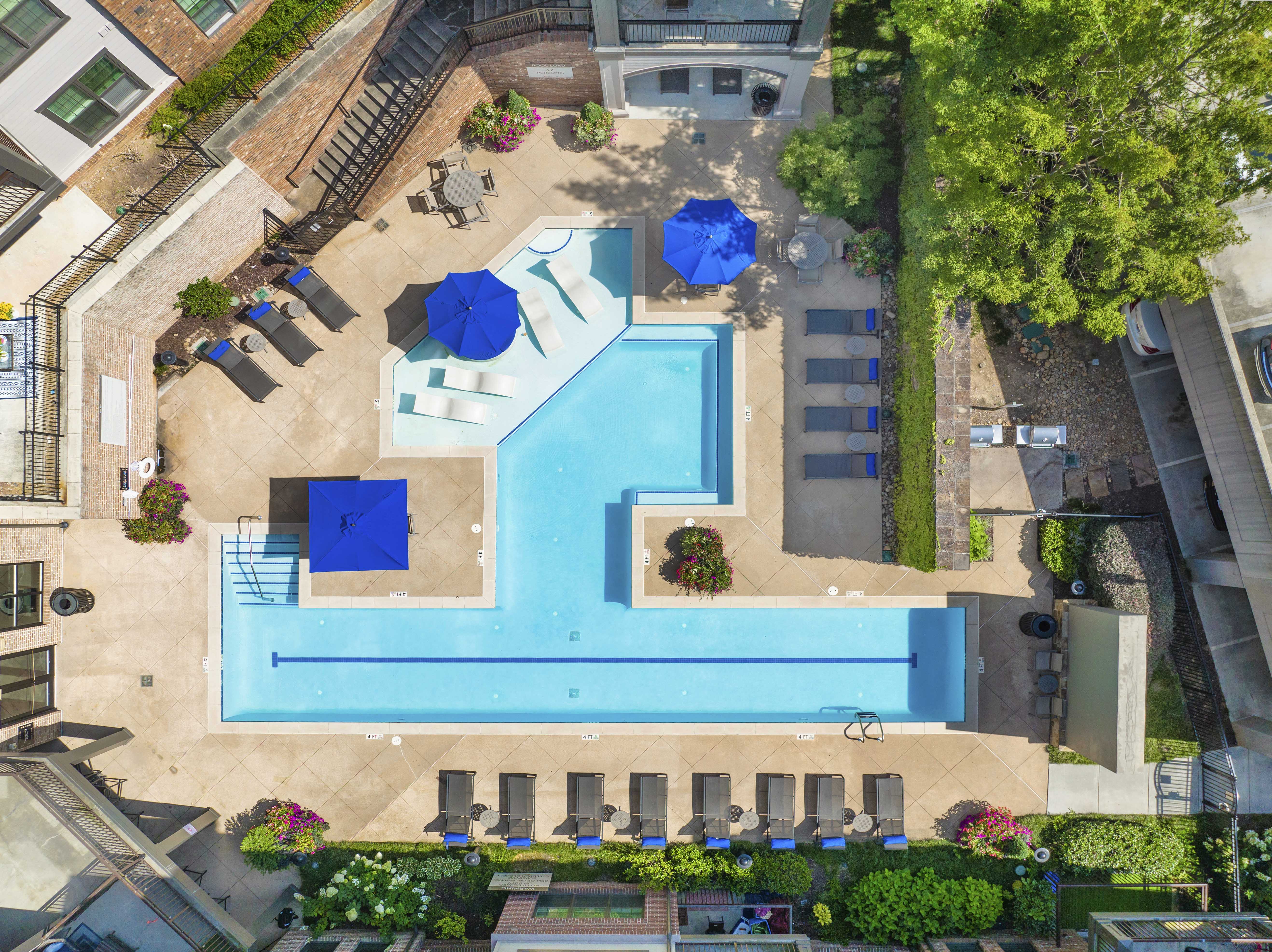 a pool area with umbrellas and chairs around it and a swimming pool