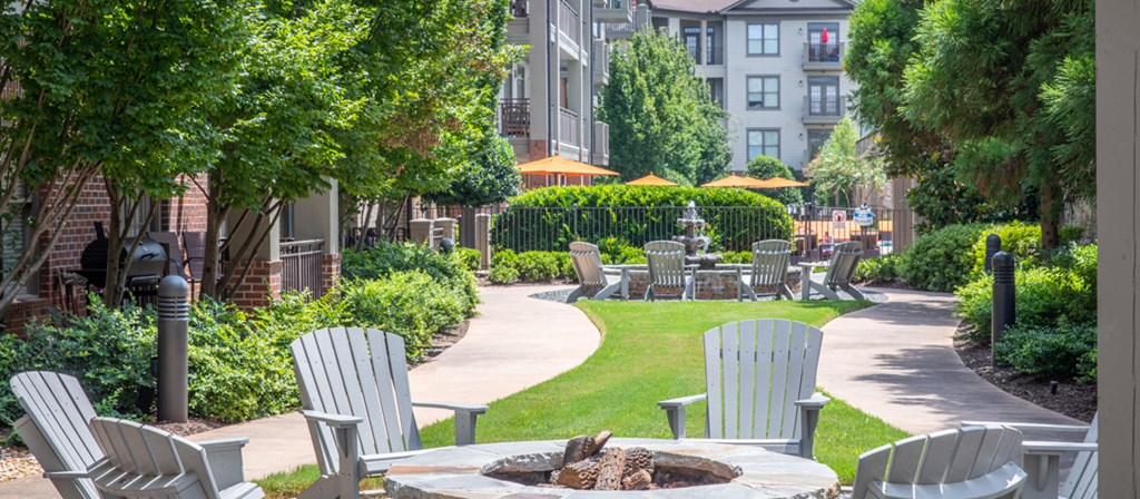 a courtyard with chairs and tables and a fire pit