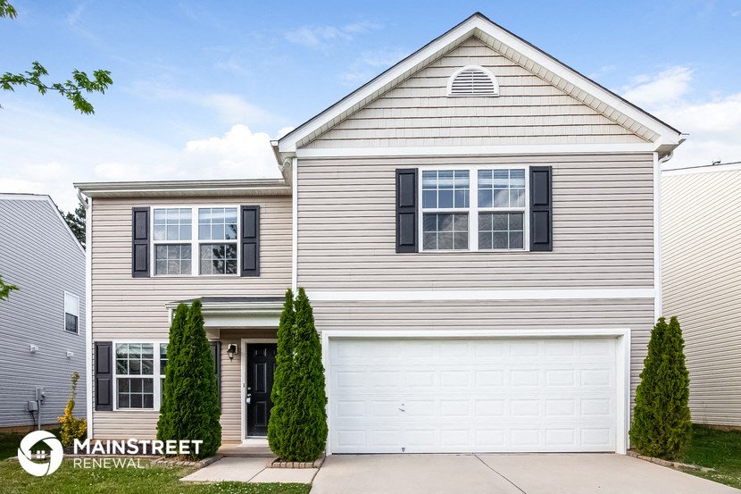 a white house with black shutters and a garage door