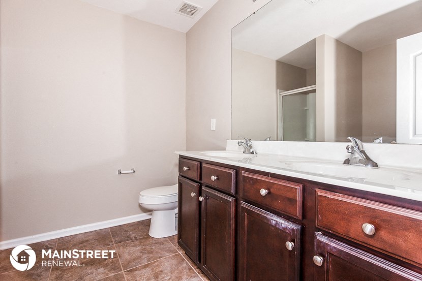 a bathroom with two sinks and a toilet and a mirror