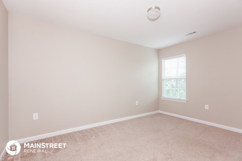 the upstairs bedroom with carpet and window