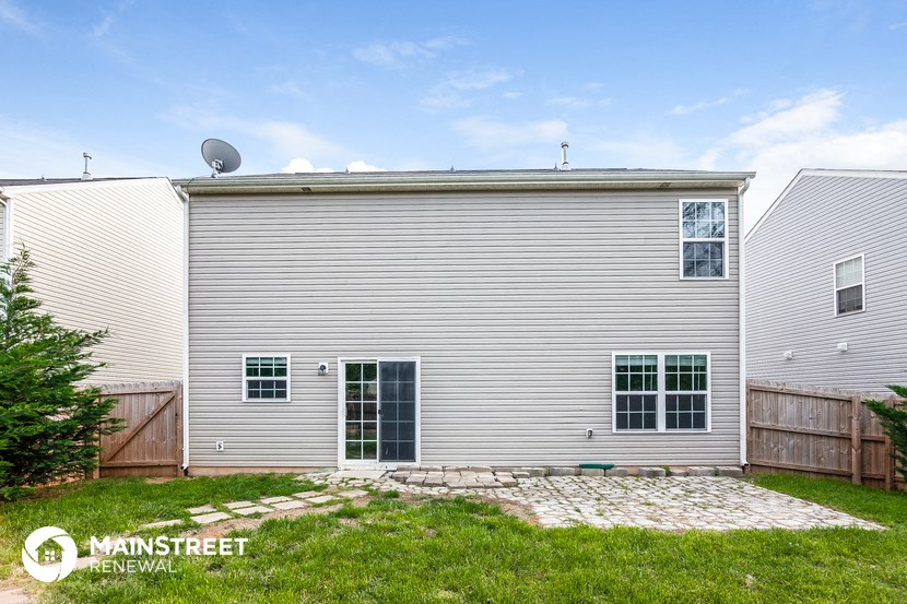 the back of a house with a garage and a yard