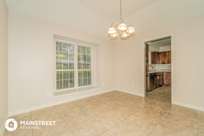 the living room and dining room are spacious and lighted by a chandelier