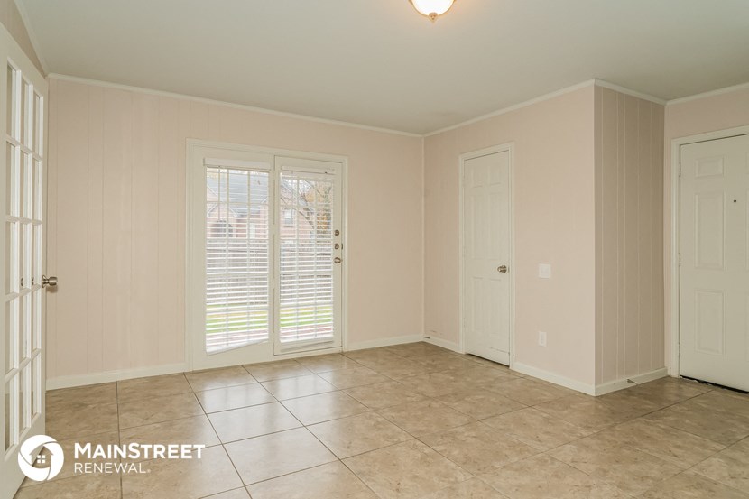 the living room of a home with a tile floor and white doors