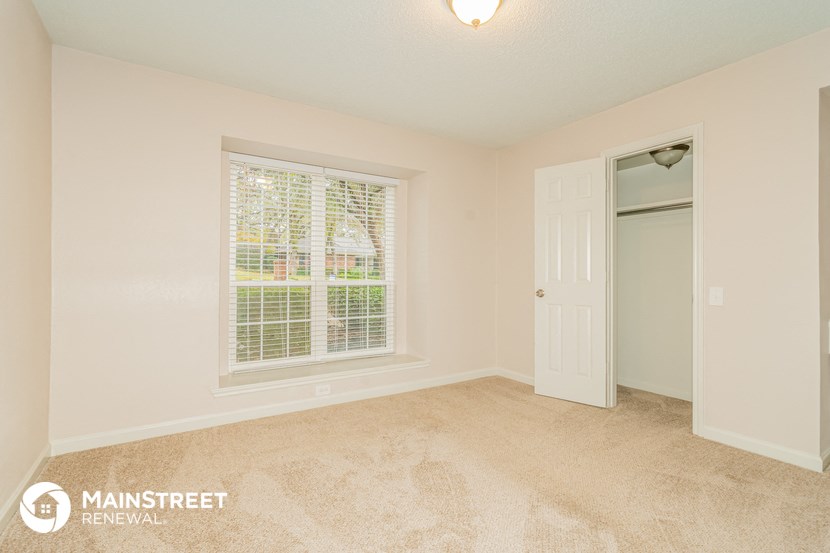 a bedroom with a large window and a white door